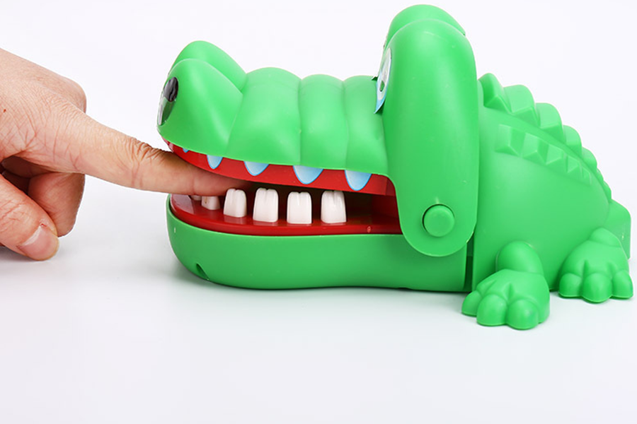 A crocodile toy that bites fingers when squeezing on its teeth
